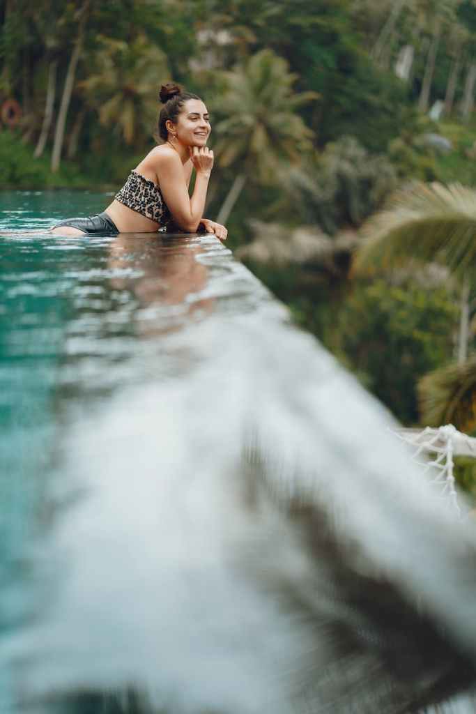 happy woman resting in pool in tropical resort