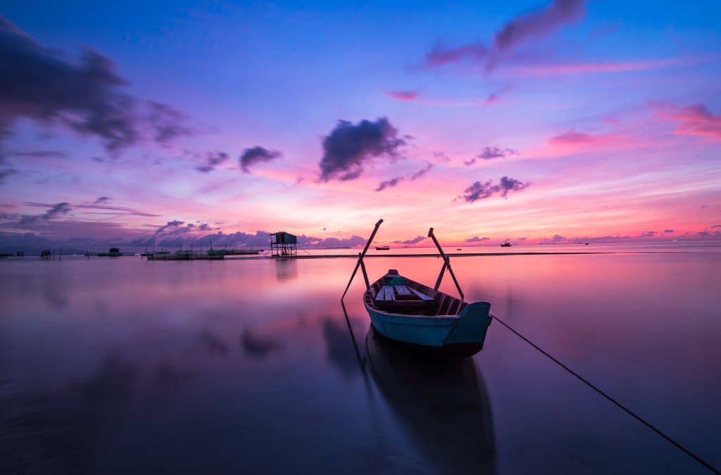 A boat on the calm water at sunset