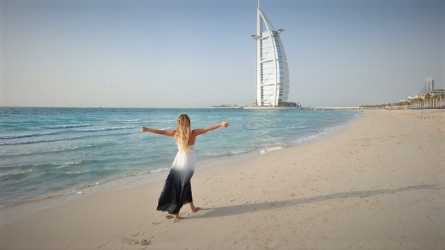a woman walking on a Dubai beach