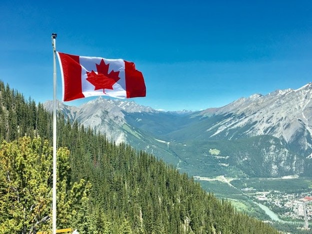 a Canadian flag and mountain ranges 