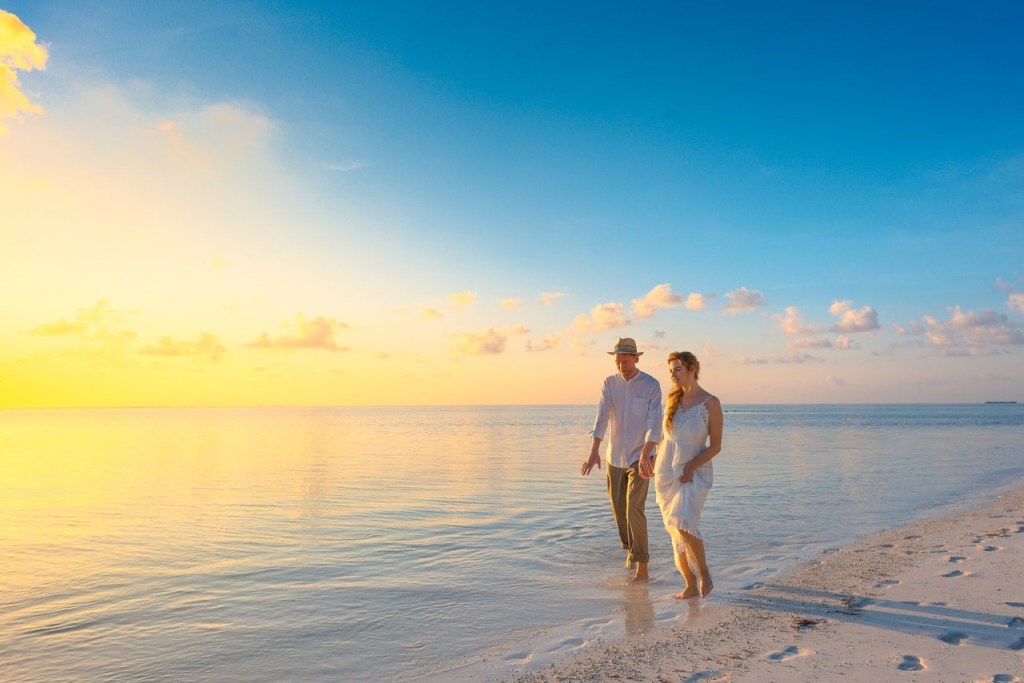 Couple walking on the seashore during sunset