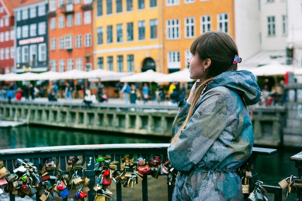 A picture of a woman’s profile while standing on the bridge with lots of padlocks.