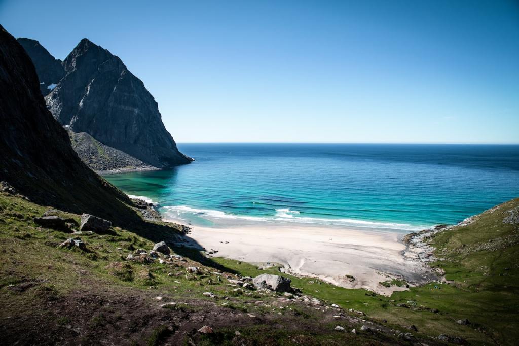A view of the beach with white sand and turquoise water.