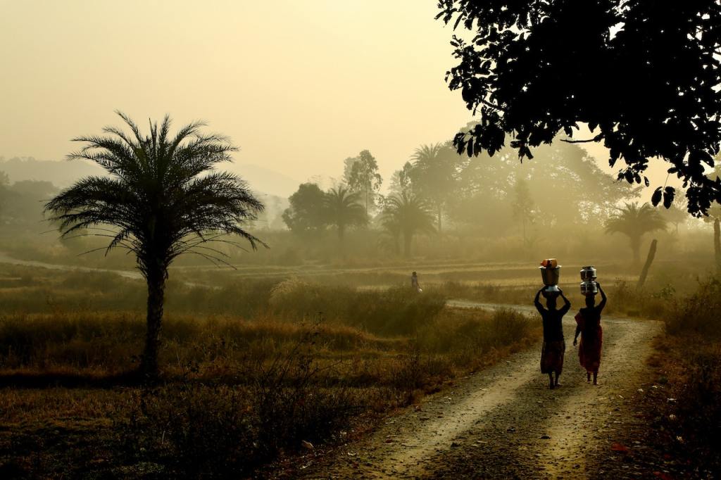 silhouette of women carrying items on their heads