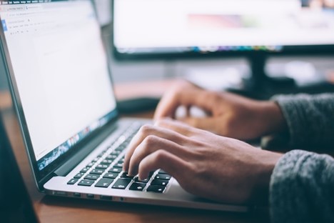 Close-up of person's hands on a keyboard