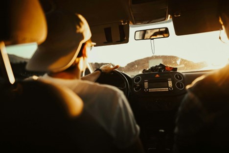 man holding a steering wheel while driving