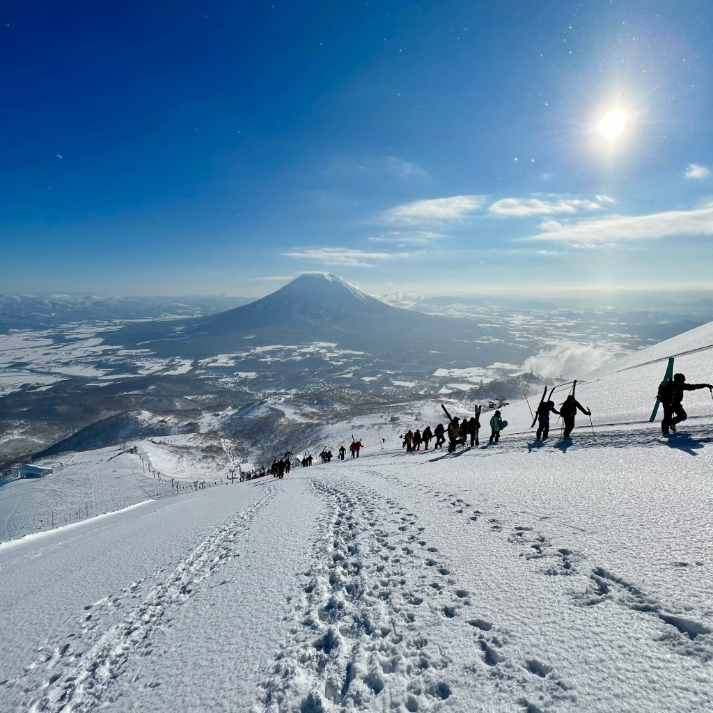 Skiers climbing up the mountain in Niseko